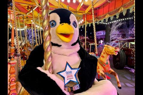 A penguin holds a trophy on a carousel at Thursford.